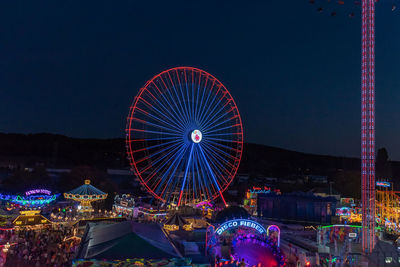 Illuminated ferris wheel against sky at night