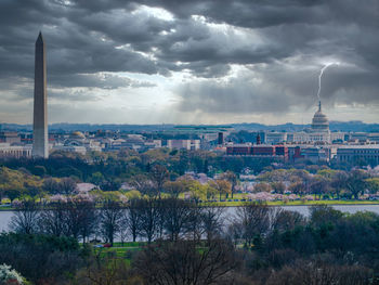 Buildings in city against cloudy sky