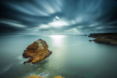 Scenic view of calm sea against cloudy sky