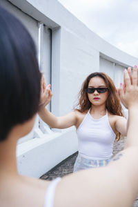 Lesbian couple touching hands while standing outdoors