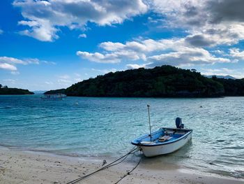 Boat moored on sea against sky