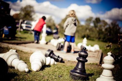 Chess pieces with children in background at park