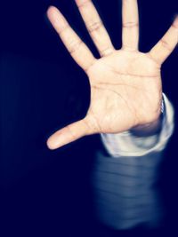 Close-up of human hand against black background