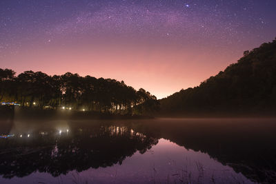 Scenic view of lake against sky at night