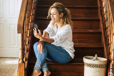 Young woman smiling while sitting on wood