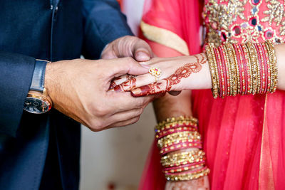 Midsection of couple holding hands