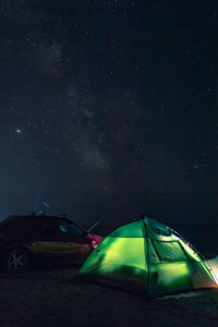 Night  camping astro photo with green tent and red car. sand beach of azov sea, dolzhanskay kosa. 