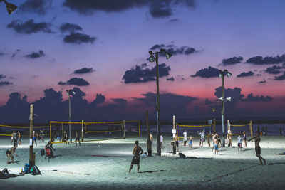 Group of people on beach at sunset