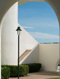 Street light by building against sky