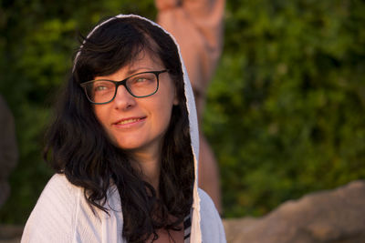 Portrait of beautiful smiling woman with hood at sunrise light