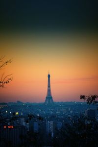 Distant view of silhouette eiffel tower in city at sunset