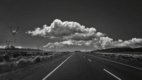 Road passing through land against sky