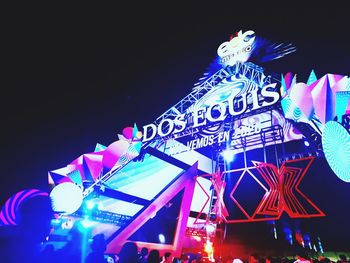 Low angle view of illuminated ferris wheel against sky at night