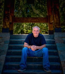 Portrait of smiling mature man sitting on steps