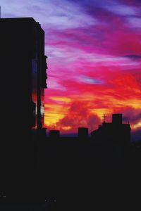 Low angle view of silhouette buildings against sky during sunset