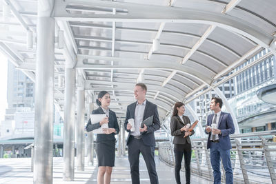 Business people discussing while standing on elevated walkway