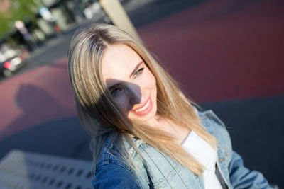 Close-up of smiling woman on footpath in city