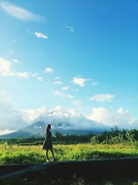 Woman looking away while standing on land