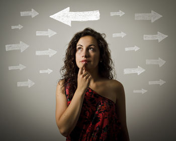 Portrait of woman standing against gray background