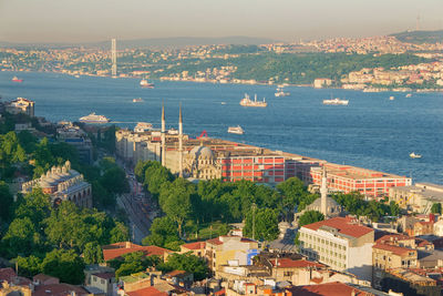 High angle view of townscape by sea against sky