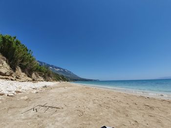 Scenic view of beach against clear blue sky