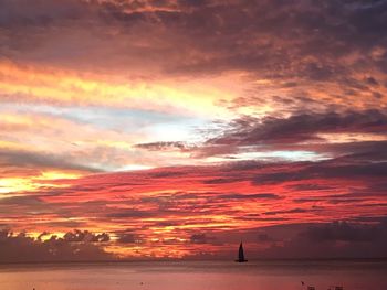 Scenic view of sea against dramatic sky during sunset