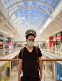 Portrait of young man standing in building.