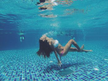 Side view full length of woman swimming in pool