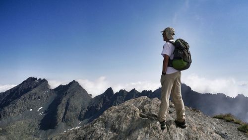Full length of woman standing on rock against clear sky