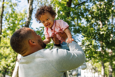 Father and son on tree against trees