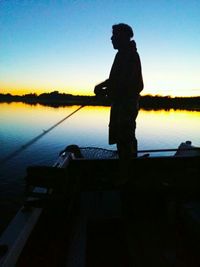 Silhouette of people in lake at sunset