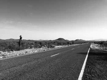 Road leading towards mountain against sky