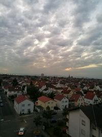 View of cityscape against cloudy sky