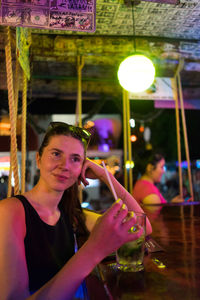 Thoughtful woman having drink in restaurant