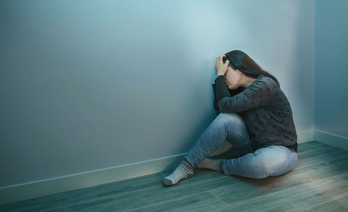 Young woman sitting on floor at home