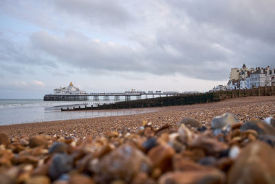 Low angle view of shingle beach with pier in the distance. selective focus.