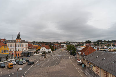 Road amidst buildings in city against sky