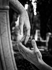 Close-up of hand touching statue