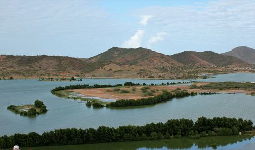 Scenic view of lake by mountains against sky