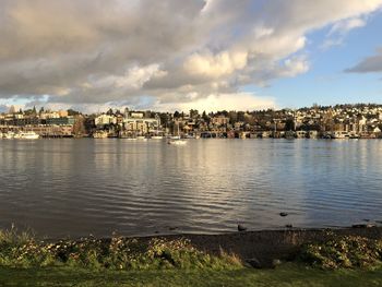 River and buildings in city against sky