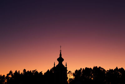 Silhouette of church against clear sky at sunset