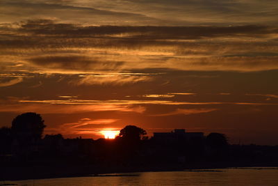 Scenic view of silhouette city against sky during sunset