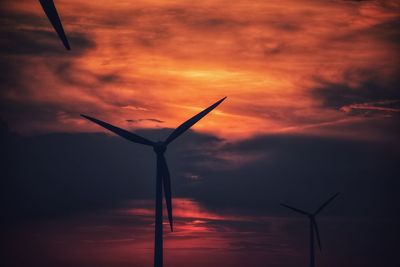 Low angle view of wind turbine against sky during sunset