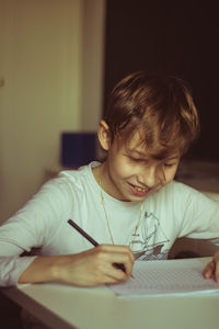 Boy holding paper at home