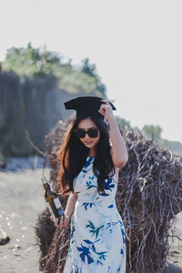 Side view of young woman looking away while standing at beach