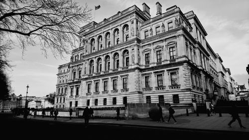 People walking on road along buildings