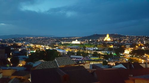 Illuminated cityscape against sky at night