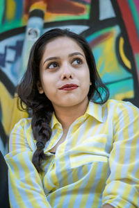 Smiling young woman against graffiti wall