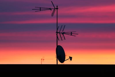 Silhouette antenna and satellite dish against sky during sunset