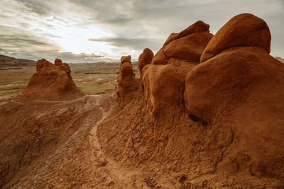 Path winds its way up bulbous red clay sandstone formations at dusk